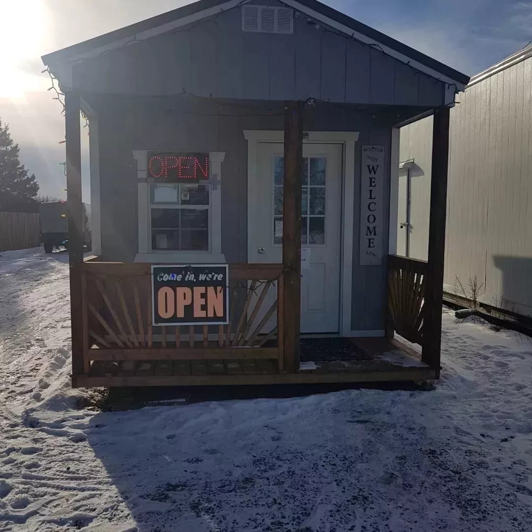 The farm store exterior in winter with snow and OPEN sign