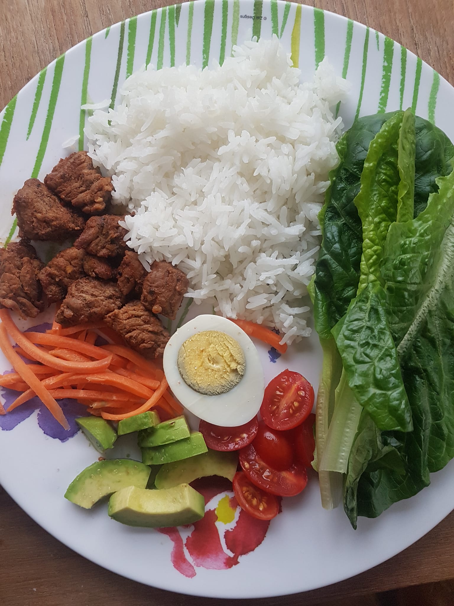 A colourful plate with rice, greens, and vegetables from the farm